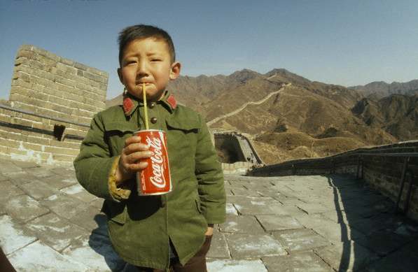 A Chinese boy drinking a Coca-cola on the Great Wall of China