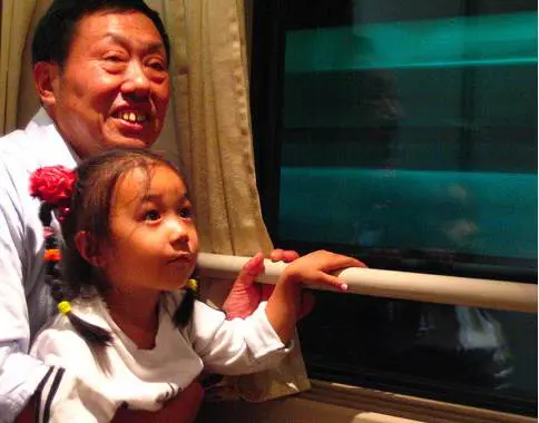 A Chinese man and daughter riding a bullet train