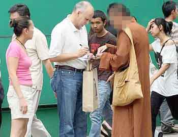 A fake monk asks a tourist for money