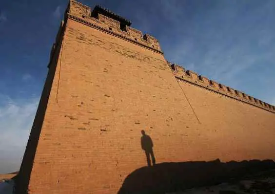 A modern city wall in China with the silhouette of a traveler
