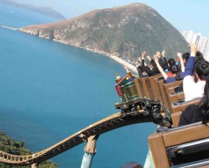 People on a rollercoaster with their hands up