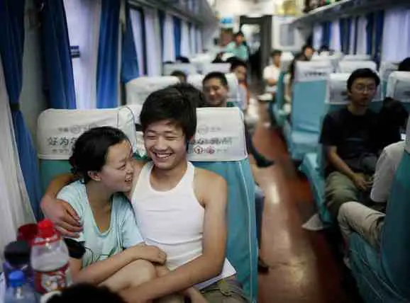 A Chinese couple sitting in soft seats on a bullet train
