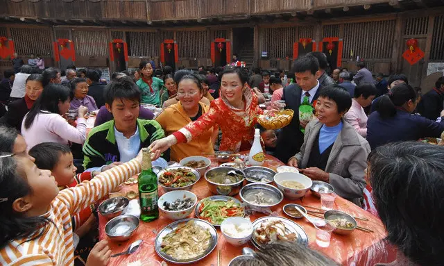 A Chinese bride toasts at a wedding table