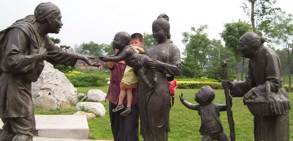 Chinese statues in a garden showing acts of friendship and kindness