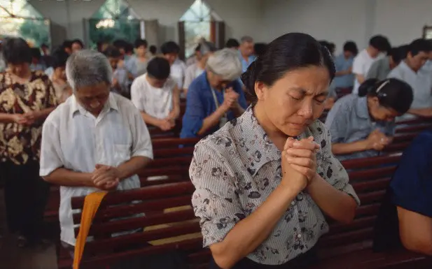 Chinese woman praying in a church 