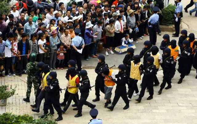 Chinese law officials escorting criminals