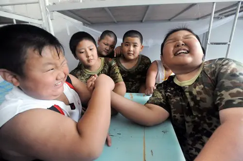 Obese Chinese children playing arm wrestling