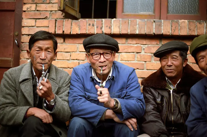 Chinese men sit together smoking