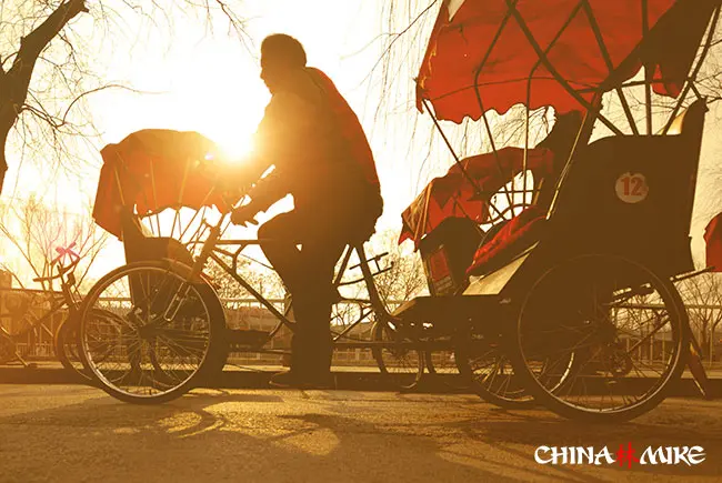 Rickshaw driver in China at dusk